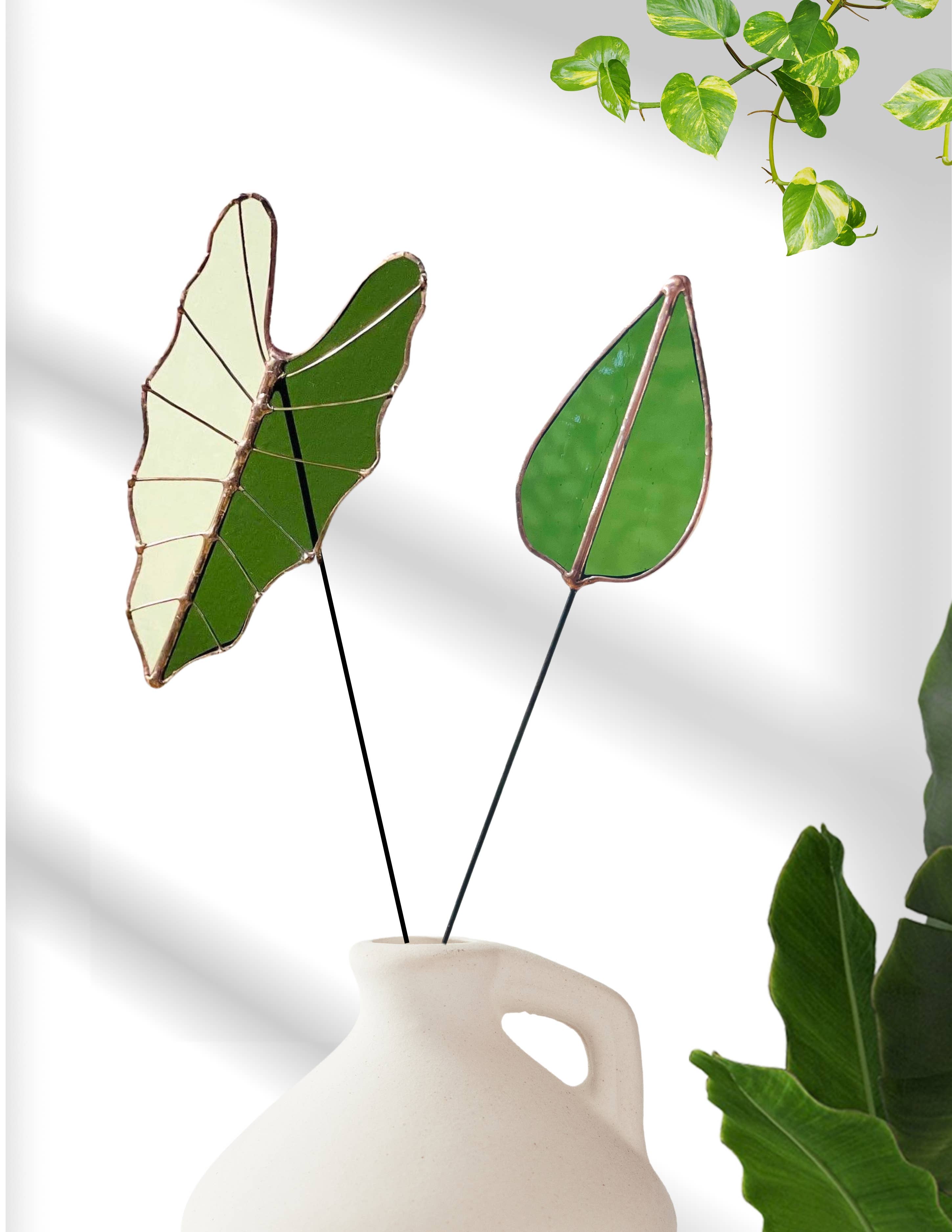 Bring a pop of color and artistry to your home with this handcrafted stained glass mulberry leaf stem by Samara Designs Studio. This stem is made from transparent earthy green stained glass with copper accents, evoking the solid, grounding tones of nature. Each piece is carefully handmade to create a lasting botanical accent that will never wilt or fade.
