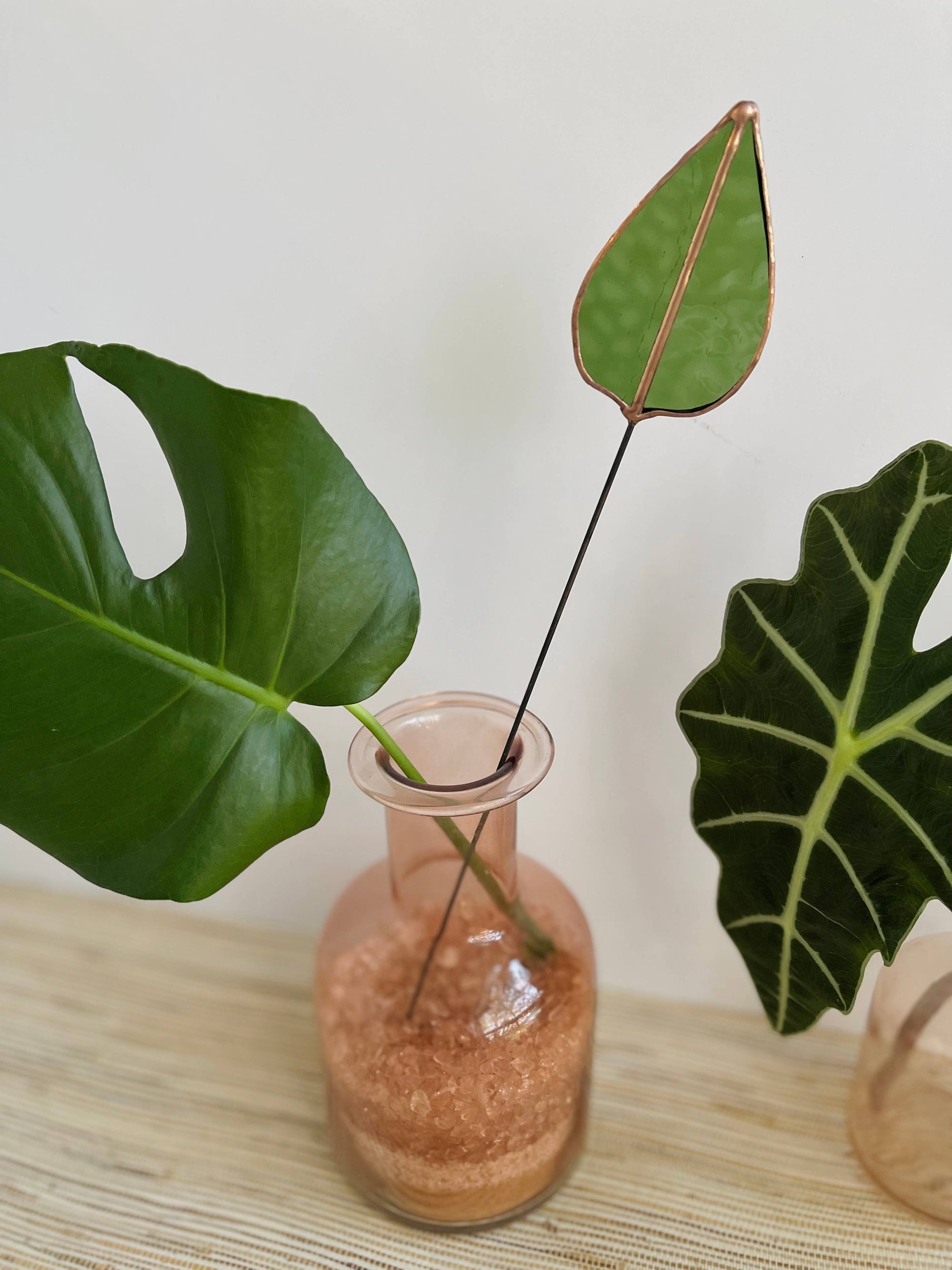 Bring a pop of color and artistry to your home with this handcrafted stained glass mulberry leaf stem by Samara Designs Studio. This stem is made from transparent earthy green stained glass with copper accents, evoking the solid, grounding tones of nature. Each piece is carefully handmade to create a lasting botanical accent that will never wilt or fade.