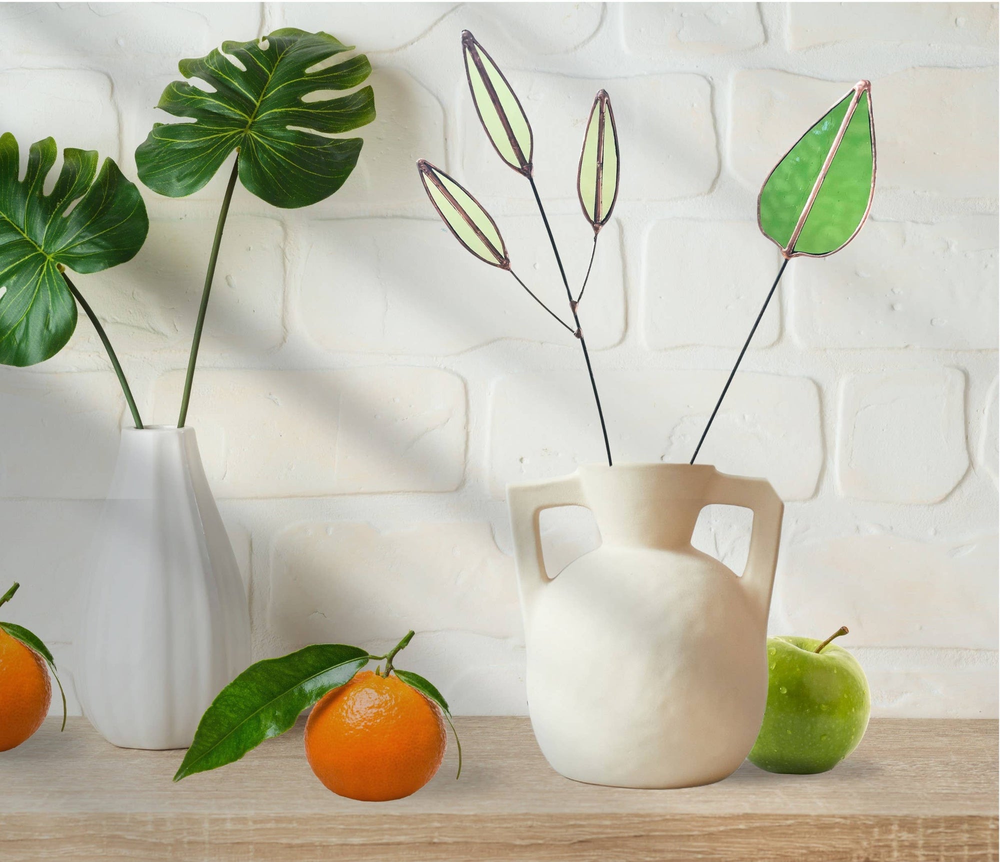 Bring a pop of color and artistry to your home with this handcrafted stained glass mulberry leaf stem by Samara Designs Studio. This stem is made from transparent earthy green stained glass with copper accents, evoking the solid, grounding tones of nature. Each piece is carefully handmade to create a lasting botanical accent that will never wilt or fade.