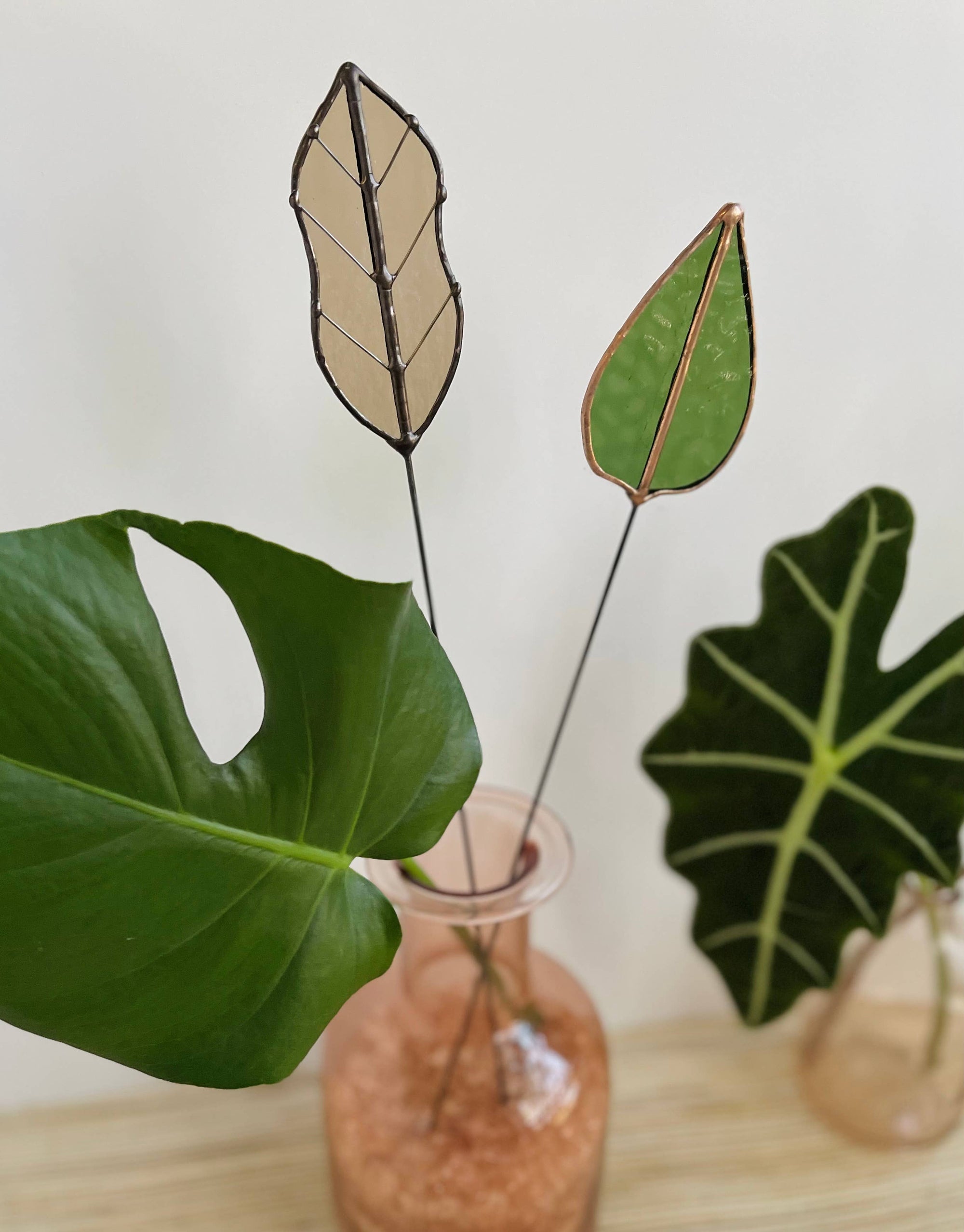 Bring a pop of color and artistry to your home with this handcrafted stained glass mulberry leaf stem by Samara Designs Studio. This stem is made from transparent earthy green stained glass with copper accents, evoking the solid, grounding tones of nature. Each piece is carefully handmade to create a lasting botanical accent that will never wilt or fade.