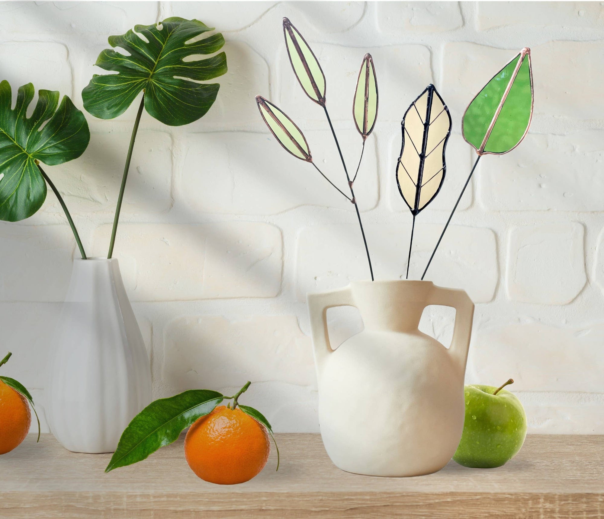 Bring a pop of color and artistry to your home with this handcrafted stained glass mulberry leaf stem by Samara Designs Studio. This stem is made from transparent earthy green stained glass with copper accents, evoking the solid, grounding tones of nature. Each piece is carefully handmade to create a lasting botanical accent that will never wilt or fade.