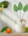 Bring a pop of color and artistry to your home with this handcrafted stained glass mulberry leaf stem by Samara Designs Studio. This stem is made from transparent earthy green stained glass with copper accents, evoking the solid, grounding tones of nature. Each piece is carefully handmade to create a lasting botanical accent that will never wilt or fade.