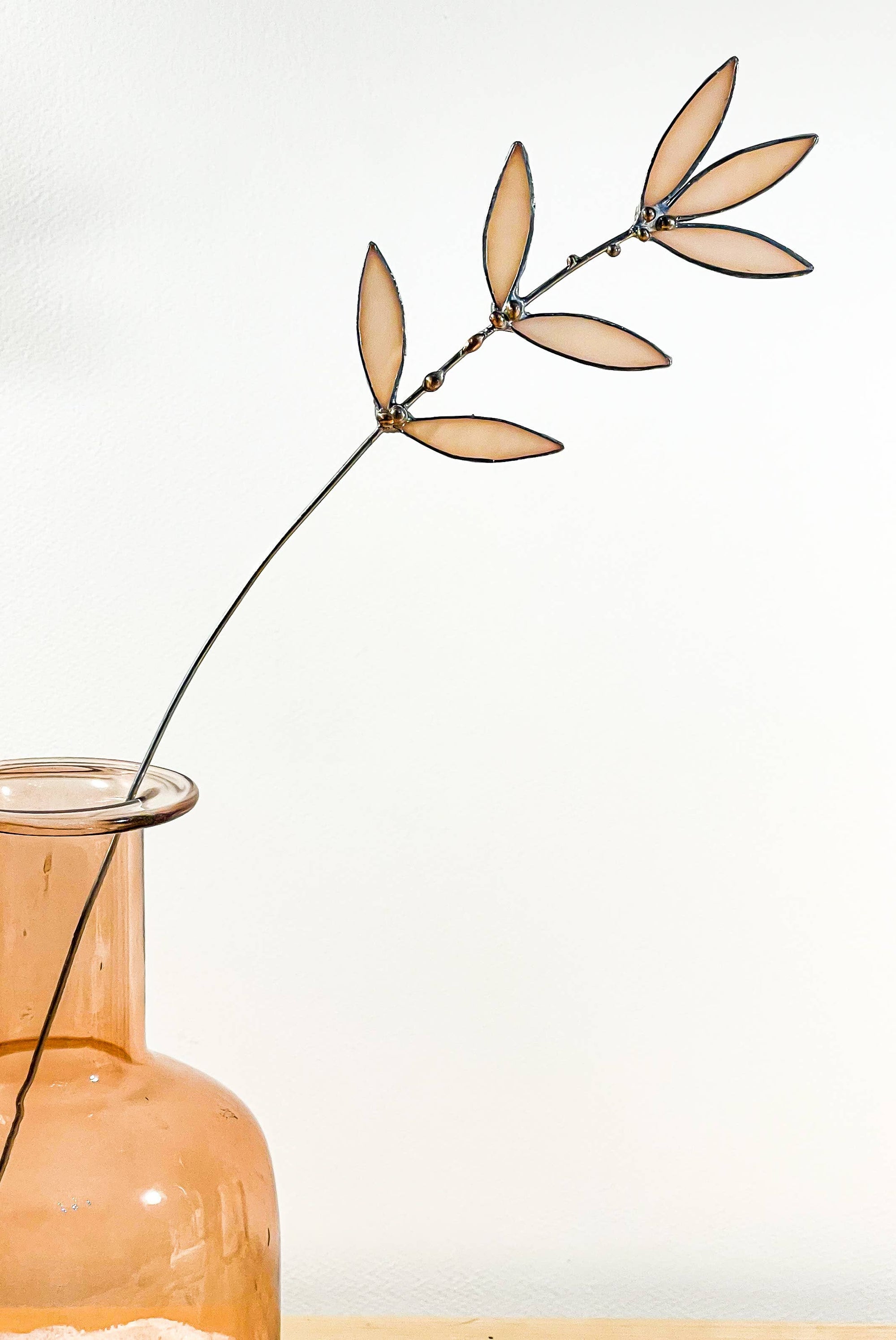 Bring a pop of color and artistry to your home with this handcrafted stained glass peachy pink wildflower by Samara Designs Studio. This delicate sprig is handmade using peachy pink stained glass. Each piece of glass is hand cut and meticulously crafted using the traditional stained glass copper foil technique to create a lasting botanical accent that will never wilt or fade.