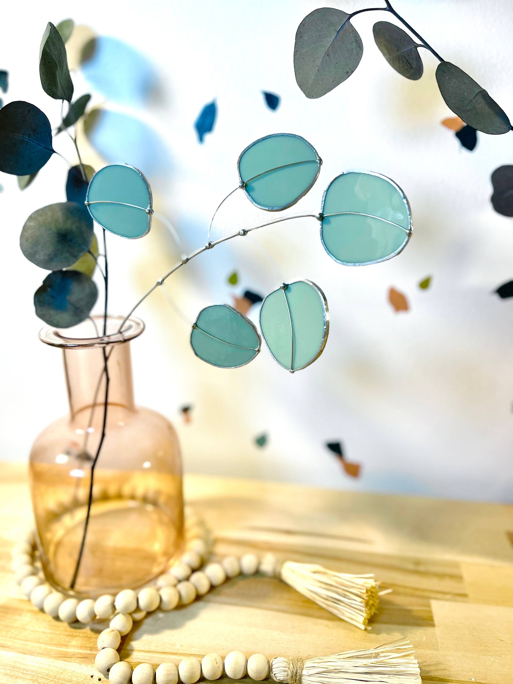 Bring a pop of color and artistry to your home with this handcrafted stained glass silver dollar eucalyptus stem by Samara Designs Studio. This stem is made from beautiful celadon green stained glass, carefully cut and assembled by hand to create a lasting botanical accent that will never wilt or fade.