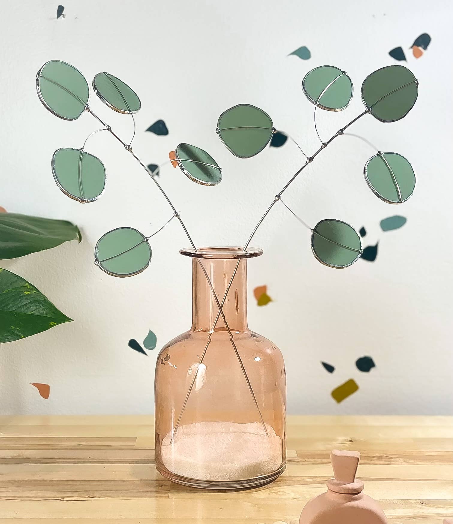 Bring a pop of color and artistry to your home with this handcrafted stained glass silver dollar eucalyptus stem by Samara Designs Studio. This stem is made from beautiful celadon green stained glass, carefully cut and assembled by hand to create a lasting botanical accent that will never wilt or fade.