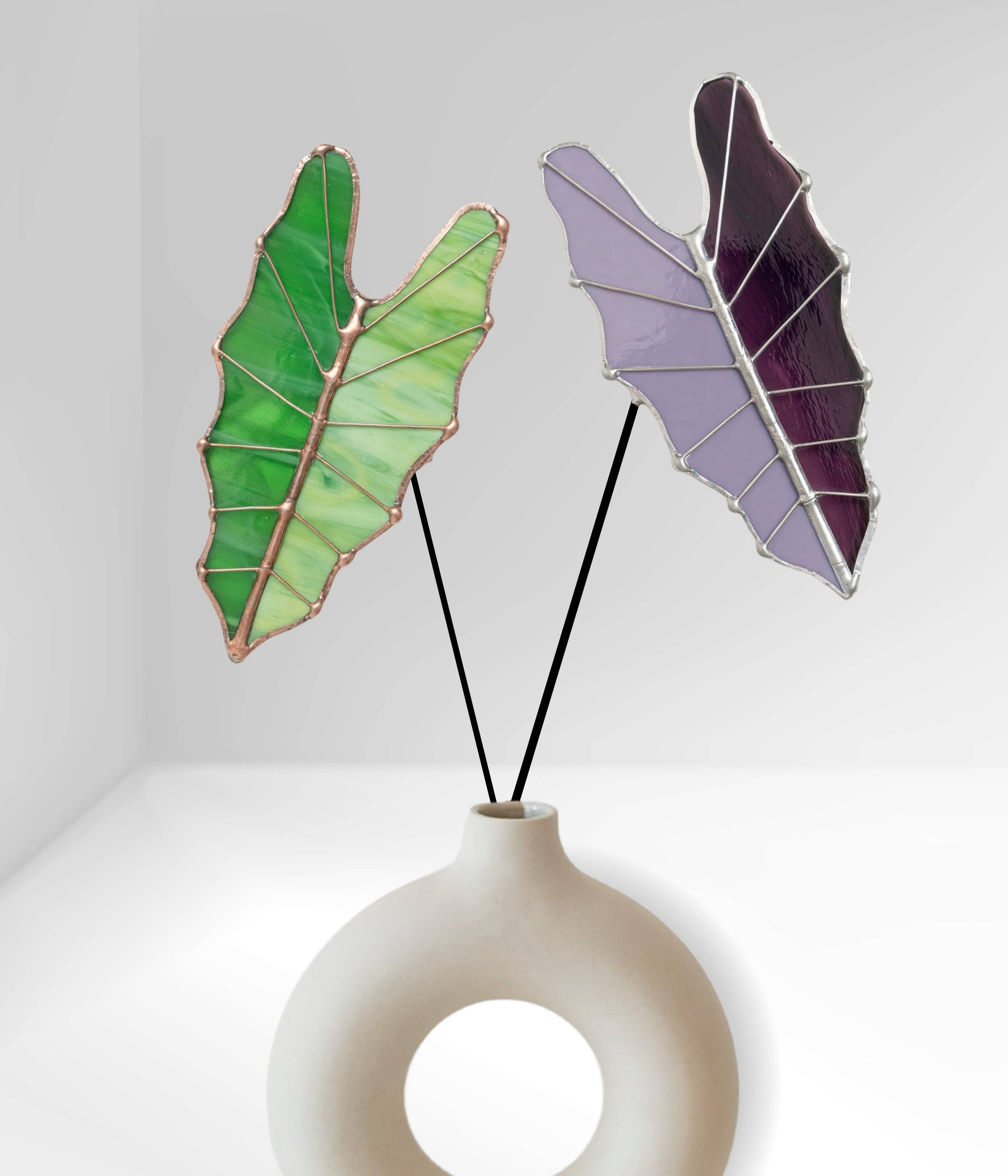 Bring a pop of color and artistry to your home with this handcrafted stained glass tropical green Alocasia leaf by Samara Designs Studio. This artistic interpretation captures the unique shape of the Alocasia leaf in lasting stained glass that will never wilt or fade. Each leaf is carefully handmade using stained glass and galvanized steel wire for a durable botanical accent.