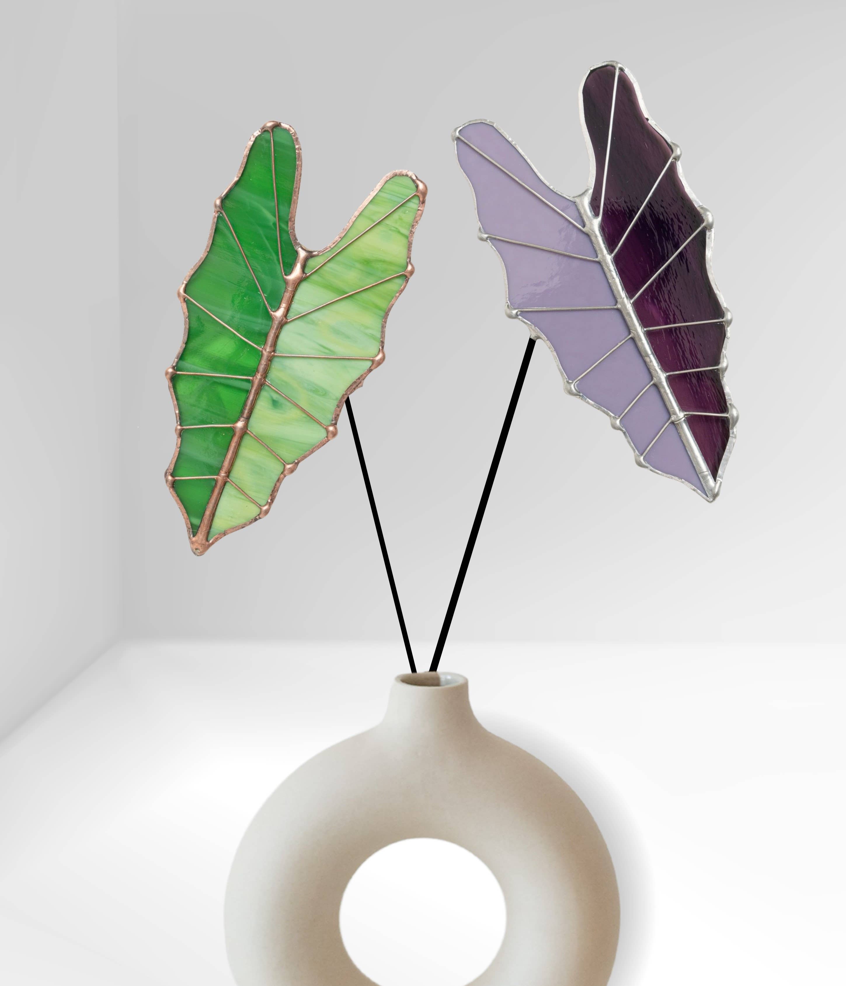 Bring a pop of color and artistry to your home with this handcrafted stained glass tropical green Alocasia leaf by Samara Designs Studio. This artistic interpretation captures the unique shape of the Alocasia leaf in lasting stained glass that will never wilt or fade. Each leaf is carefully handmade using stained glass and galvanized steel wire for a durable botanical accent.