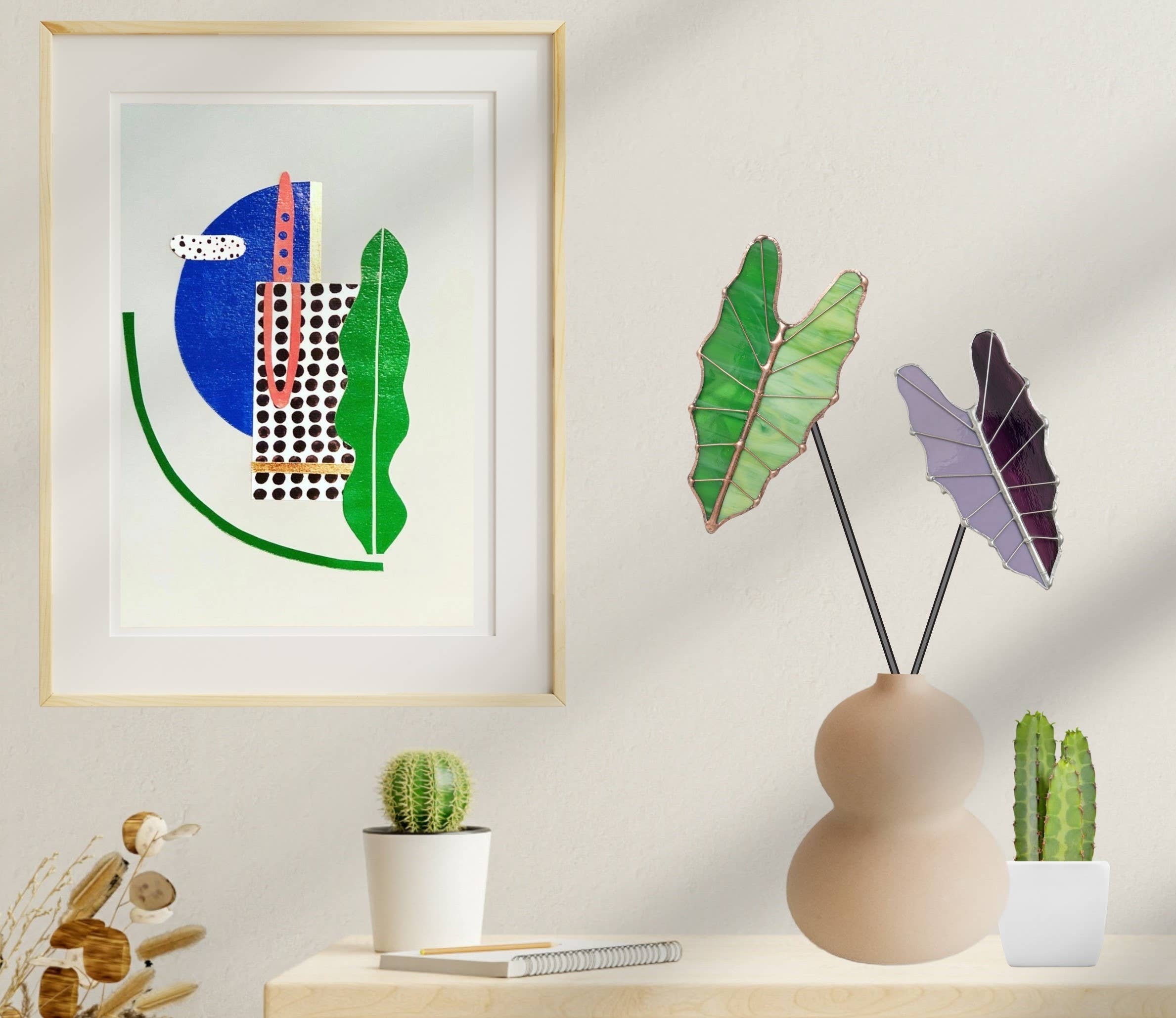 Bring a pop of color and artistry to your home with this handcrafted stained glass tropical green Alocasia leaf by Samara Designs Studio. This artistic interpretation captures the unique shape of the Alocasia leaf in lasting stained glass that will never wilt or fade. Each leaf is carefully handmade using stained glass and galvanized steel wire for a durable botanical accent.