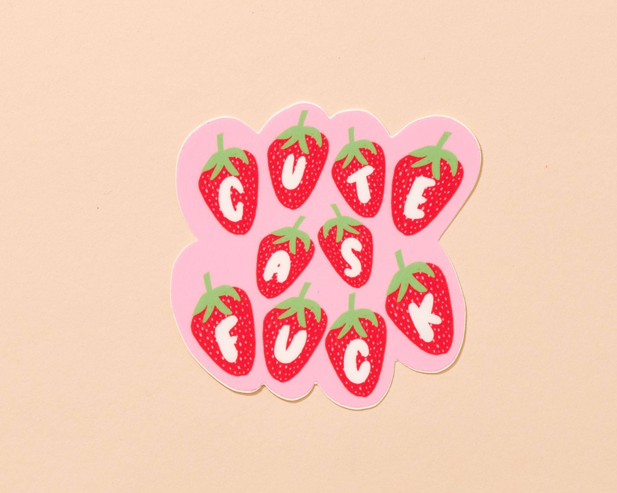Sticker with strawberry design and 'Cute as a Button' text on a beige background