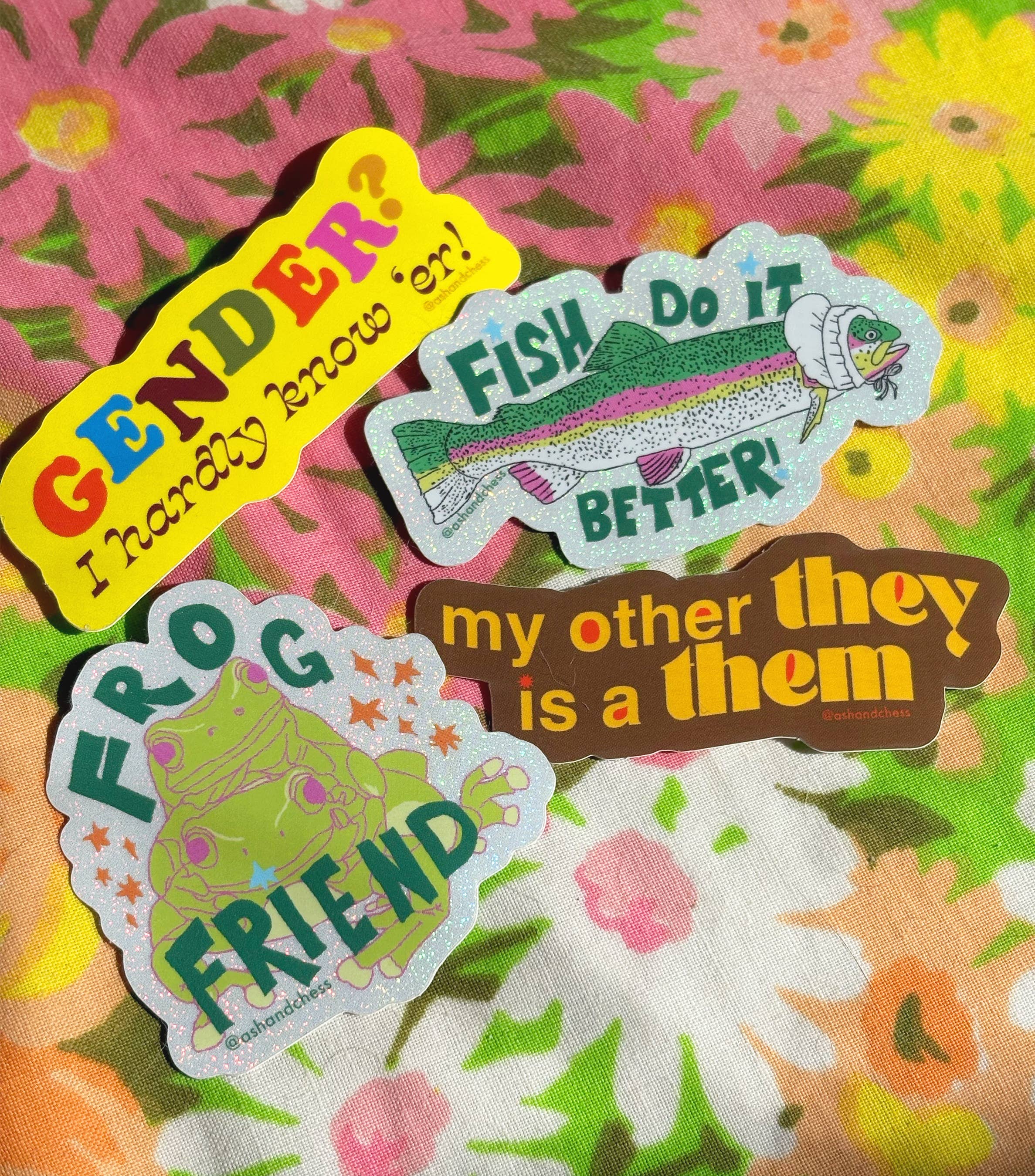 Four colorful stickers with text and graphics on a floral background