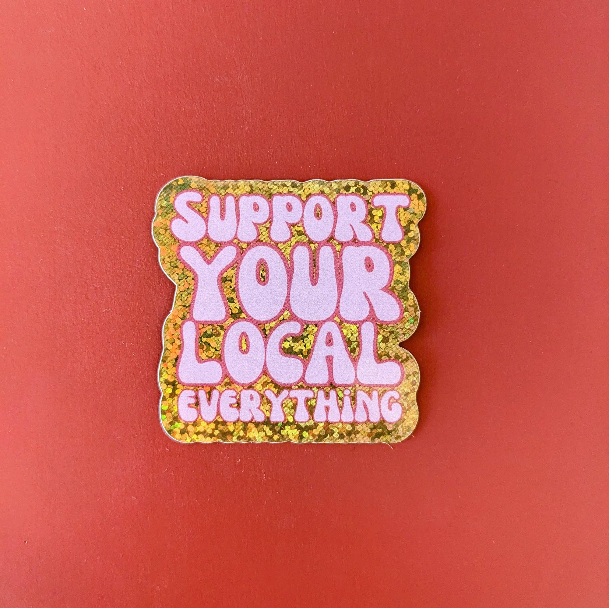 Sticker with 'Support Your Local Everything' text on a red background