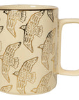 This beautifully crafted stoneware mug features a distinctive rectangular handle and a serene, moonlit design. It captures the quiet enchantment of a nocturnal landscape, with golden birds in graceful flight against a soft cream backdrop. Just the right size to fill your cup with inspiration, it’s the perfect companion for reflective mornings or calming evenings in.