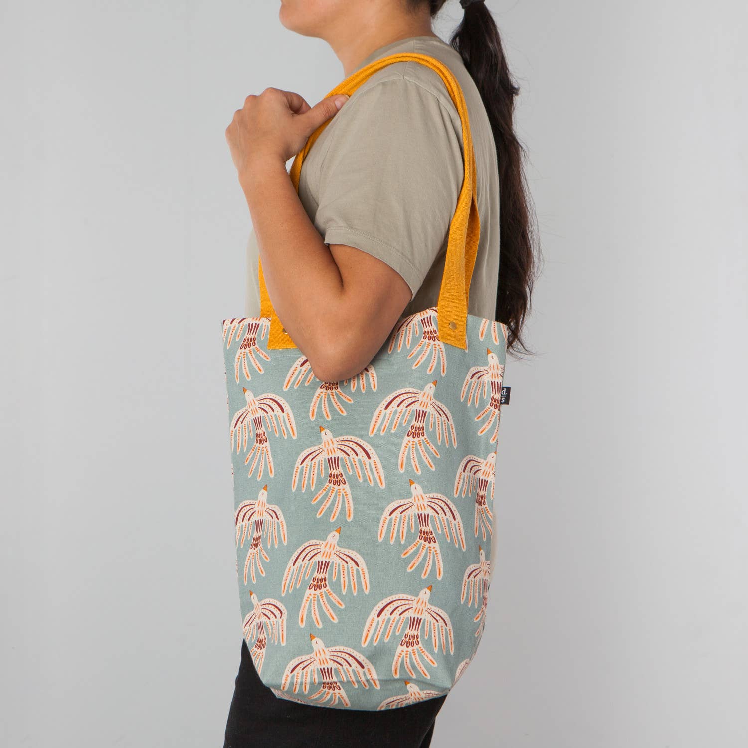 Lightweight and sturdy, this Plume Studio Tote by Danica Studio features reinforced handles and a bold feather design inspired by nature's beauty.