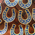 Blue and gold 'Good Luck' horseshoe stickers on a wooden surface