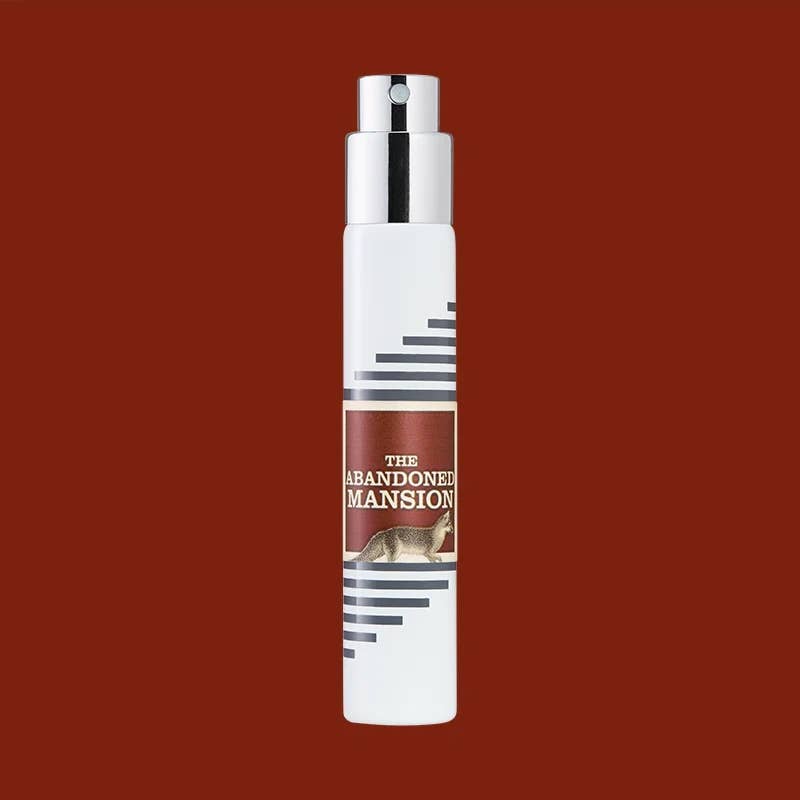 White Imaginary Authors travel spray with a brown The Abandoned Mansion label on a rust-brown background
