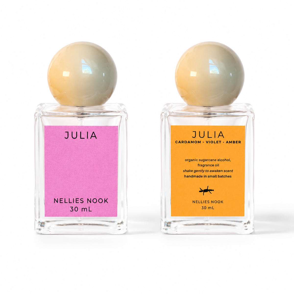 Front and back of the Julia perfume bottle, pink front label and orange back label listing cardamom, violet and amber