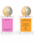 Front and back of the Julia perfume bottle, pink front label and orange back label listing cardamom, violet and amber