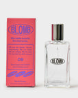 Pink Blomb No. 09 box beside a clear glass Blomb perfume bottle with a silver cap on a gray background