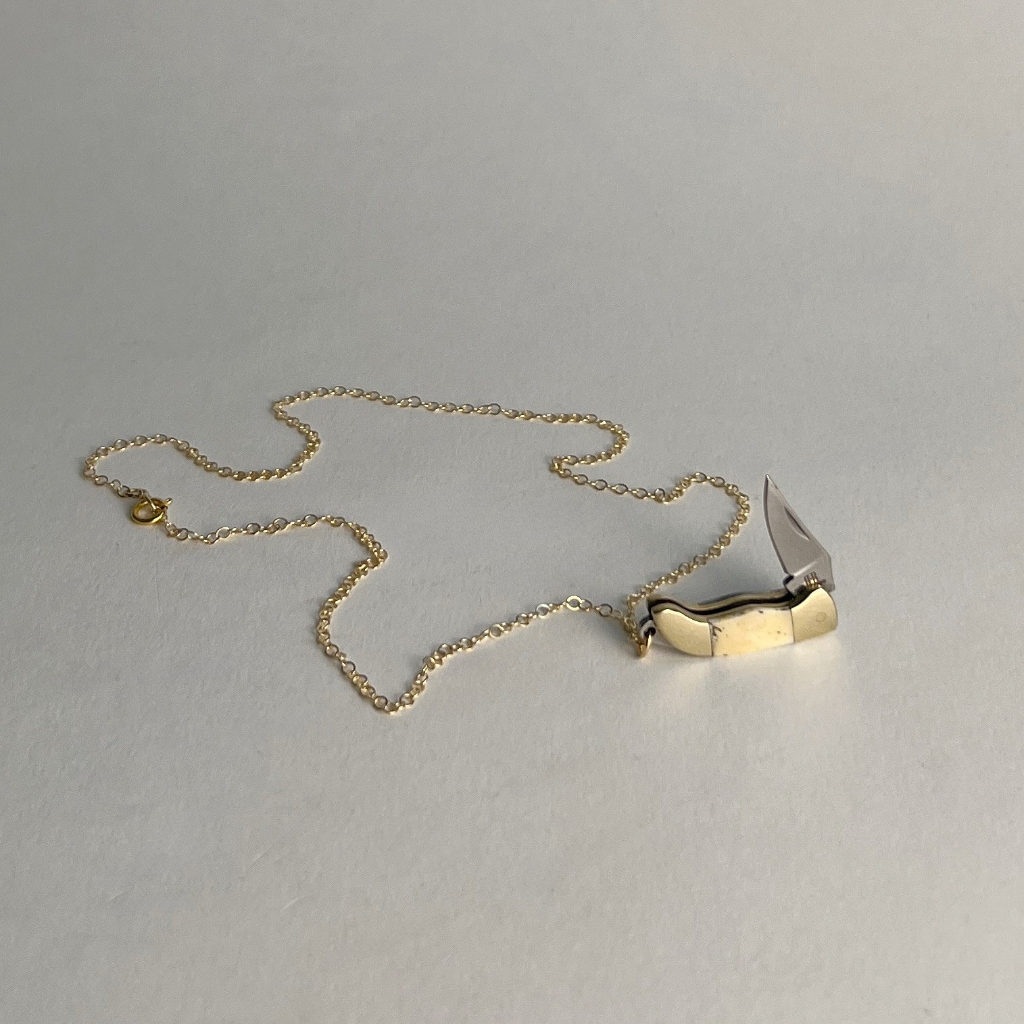 Gold-filled chain necklace laid flat with a mini bone-handled pocket knife pendant