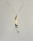 Mini bone-handled pocket knife pendant with the blade pointing down, on a gold-filled chain