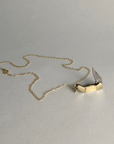 Gold-filled chain necklace laid flat with a mini bone-handled pocket knife pendant