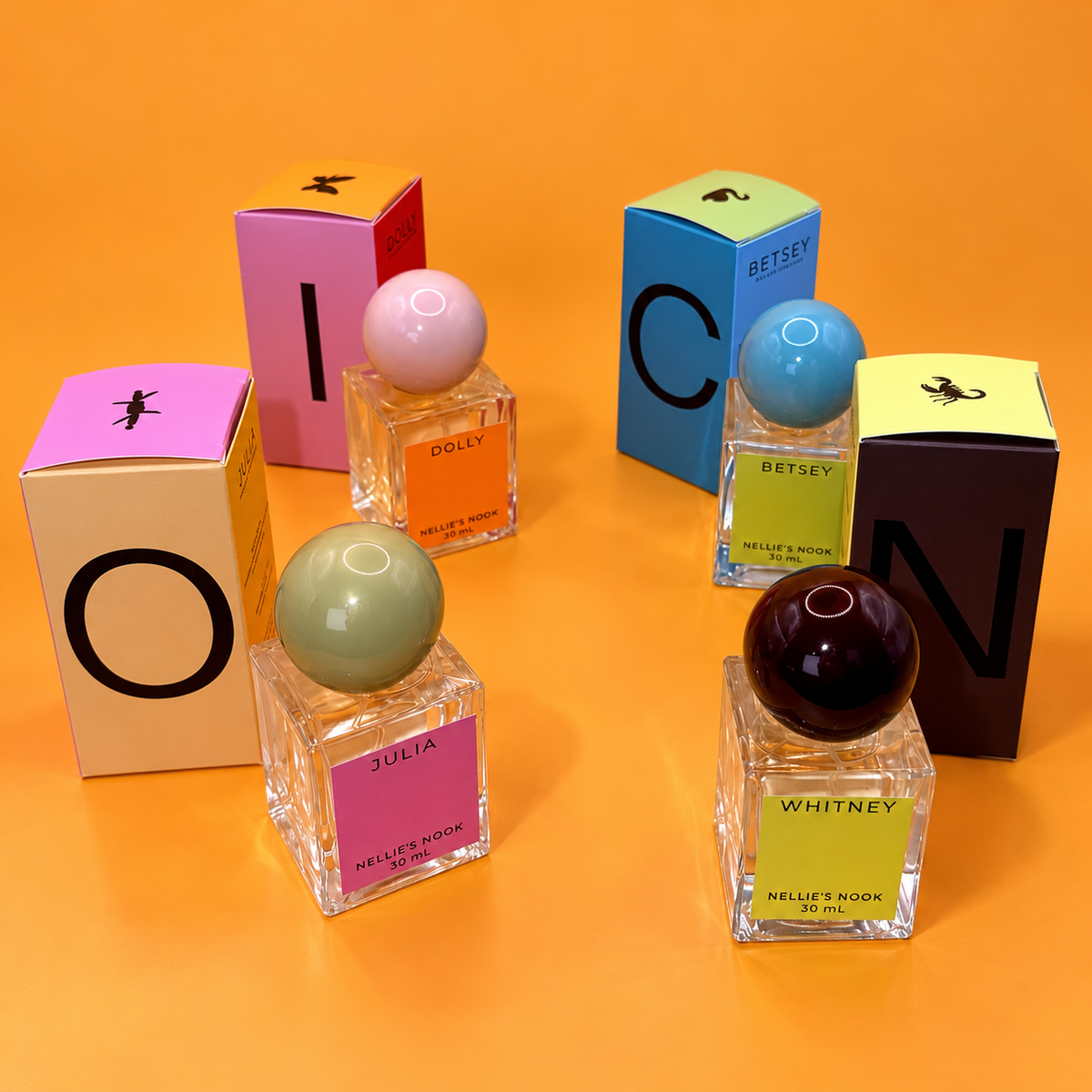 Nellie's Nook Icons perfumes Julia, Dolly, Betsey and Whitney with boxes spelling ICON on an orange background