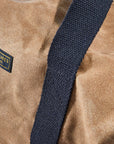 Waxed canvas duffel bag with webbing straps, padded handle and brass zipper
