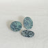 Three Kambaba jasper worry stones in green and black on white linen