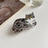 Gray striped tabby cat claw clip lying on a white table