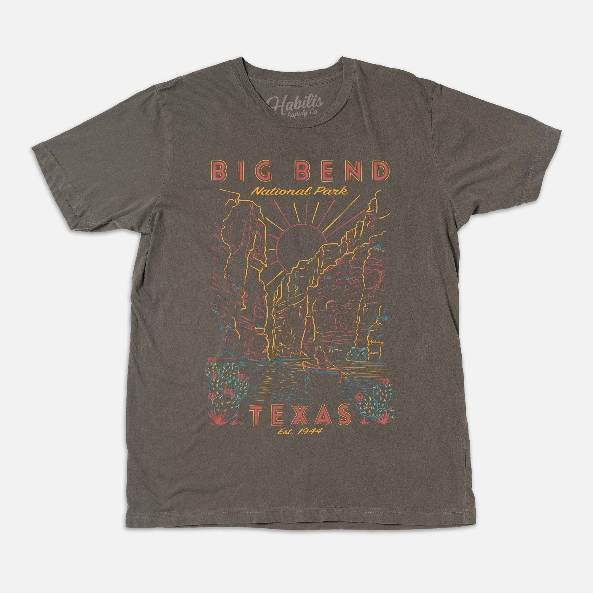 A grey short-sleeve t-shirt with a vintage-style graphic of Big Bend National Park in Texas. The graphic features yellow, orange, and red text and line art.