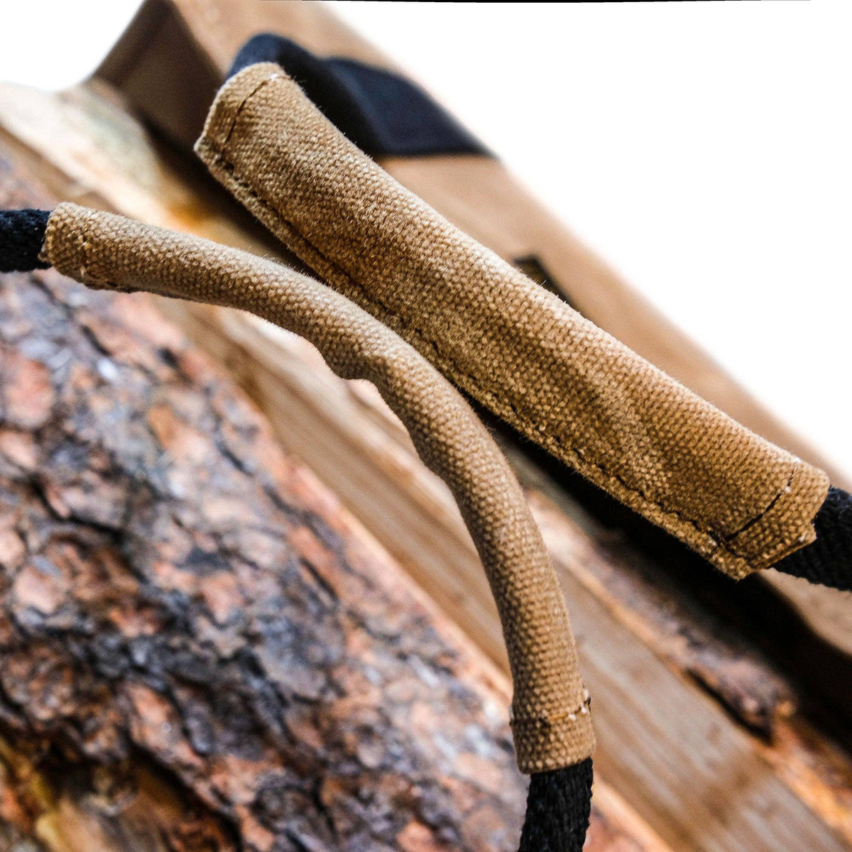 Tan waxed canvas firewood log carrier with webbing handles