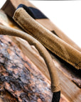 Tan waxed canvas firewood log carrier with webbing handles