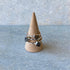 Three sterling silver labradorite rings stacked on a wooden ring cone